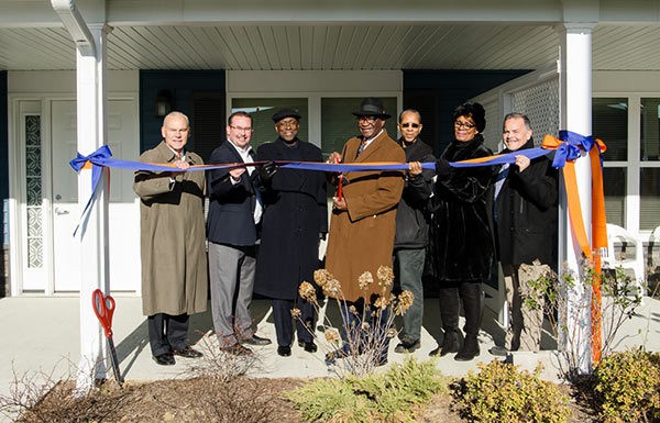 Individuals partaking in a ribbon cutting ceremony.