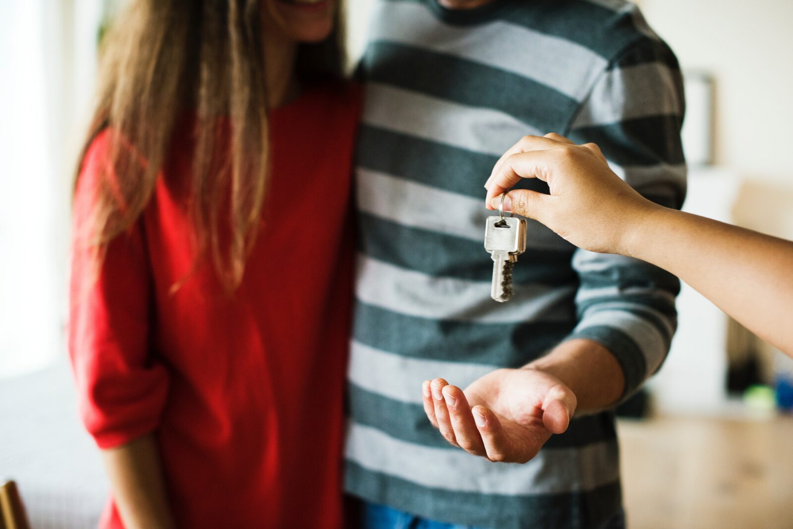 Two individuals receiving a house key.