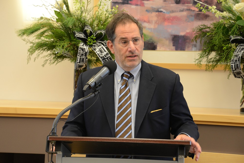 An individual in a suit speaking at a podium.