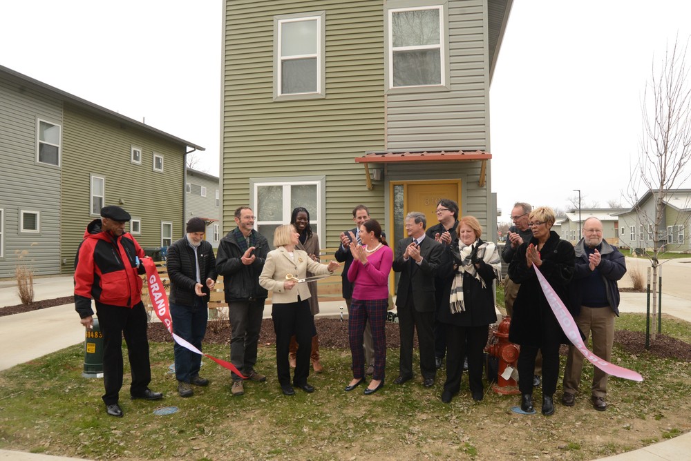 A group of individuals cutting a ribbon.