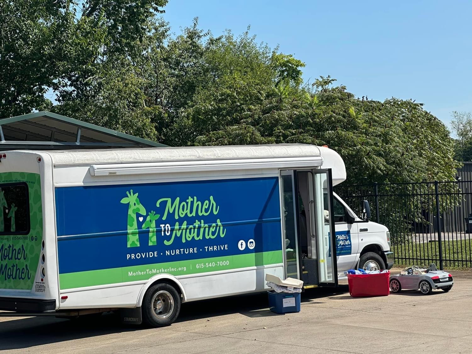 The Mother to Mother bus surrounded by toys and supplies