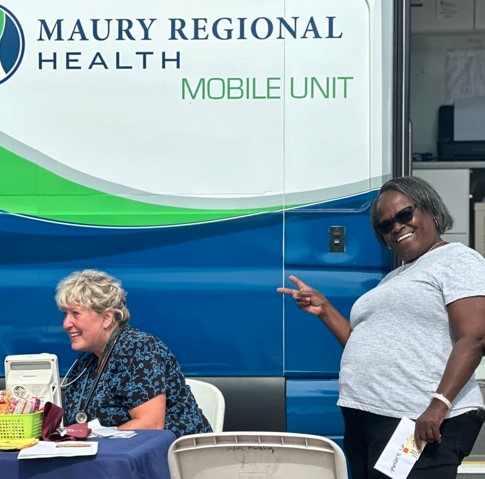 People in front of the Maury Regional Health Mobile Unit at the 2024 Family Fun Day Back-to-School Bash.