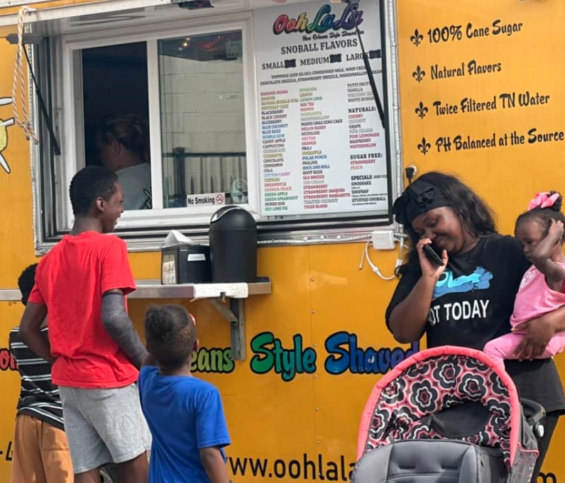 People standing at the Shaved Ice Vendor at the 2024 Family Fun Day Back-to-School Bash.