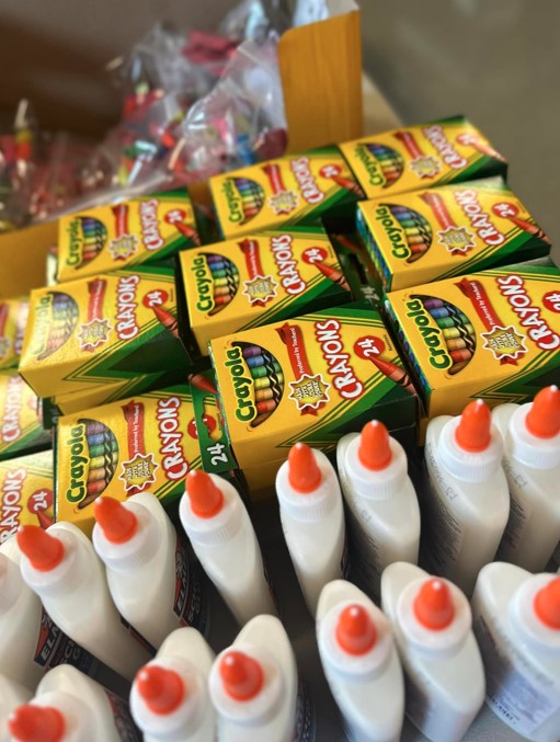 School supplies of crayons and glue at the 2024 Family Fun Day Back-to-School Bash.