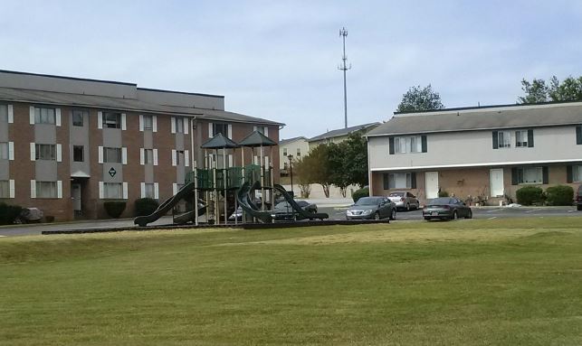 A street view of the Reserves at Faraway Terrace apartments with playground equipment in front of the buildings.