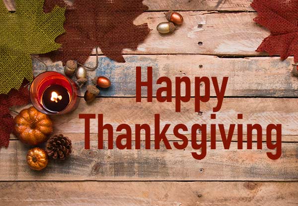 Happy Thanksgiving. Pumpkins and leaves sitting on a wooden background.