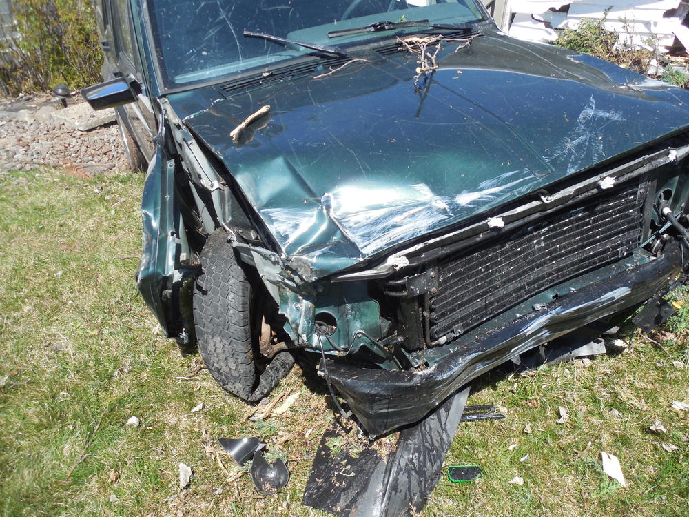 close-up of vehicle tire and front end after striking the home