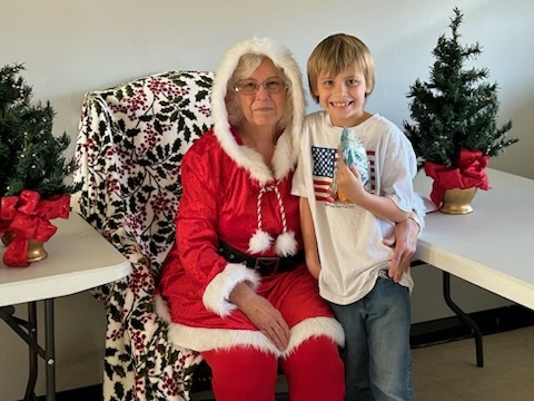 A young man smiling with Mrs. Clasue. 