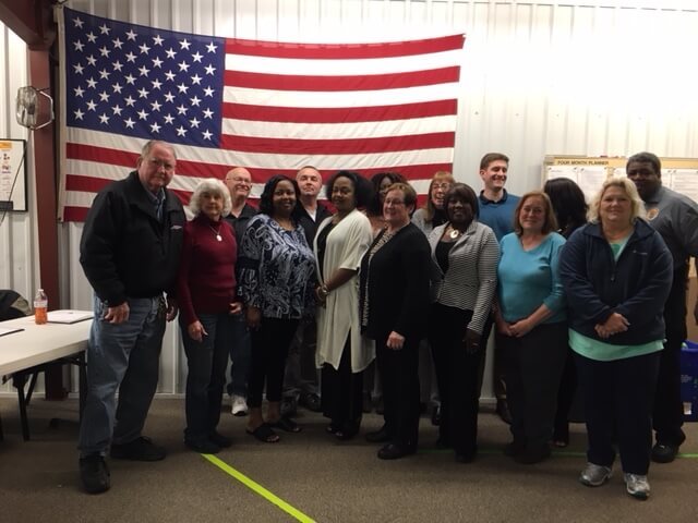 A group photo in front of an American Flag.