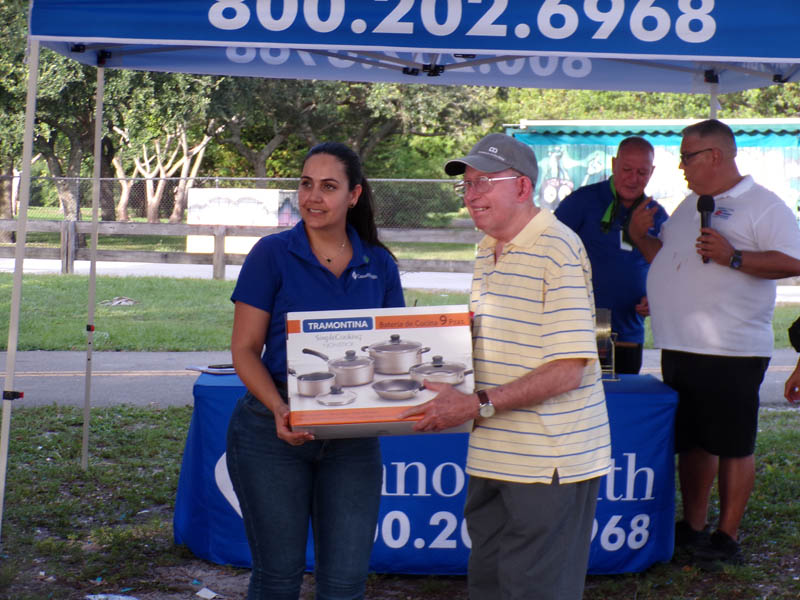 A Lady presenting a gentleman new pots and pans.