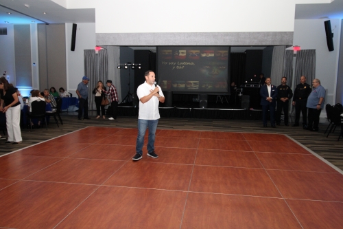 A man holding a microphone speaking.