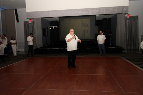 A man standing in the middle of the dance floor pointing.