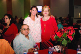 Two women and a man smiling for a photo.