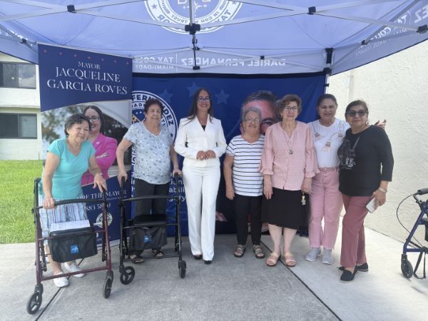 Mayor Jacqueline Garcia Roves smiles with seven people for a picture.