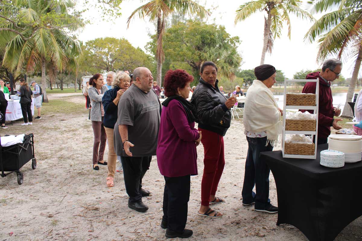 People standing in line waiting to get breakfast.