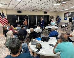 Speaker talking with a group in a lunchroom. 