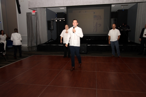 Man smiling on the dance floor holding the microphone.