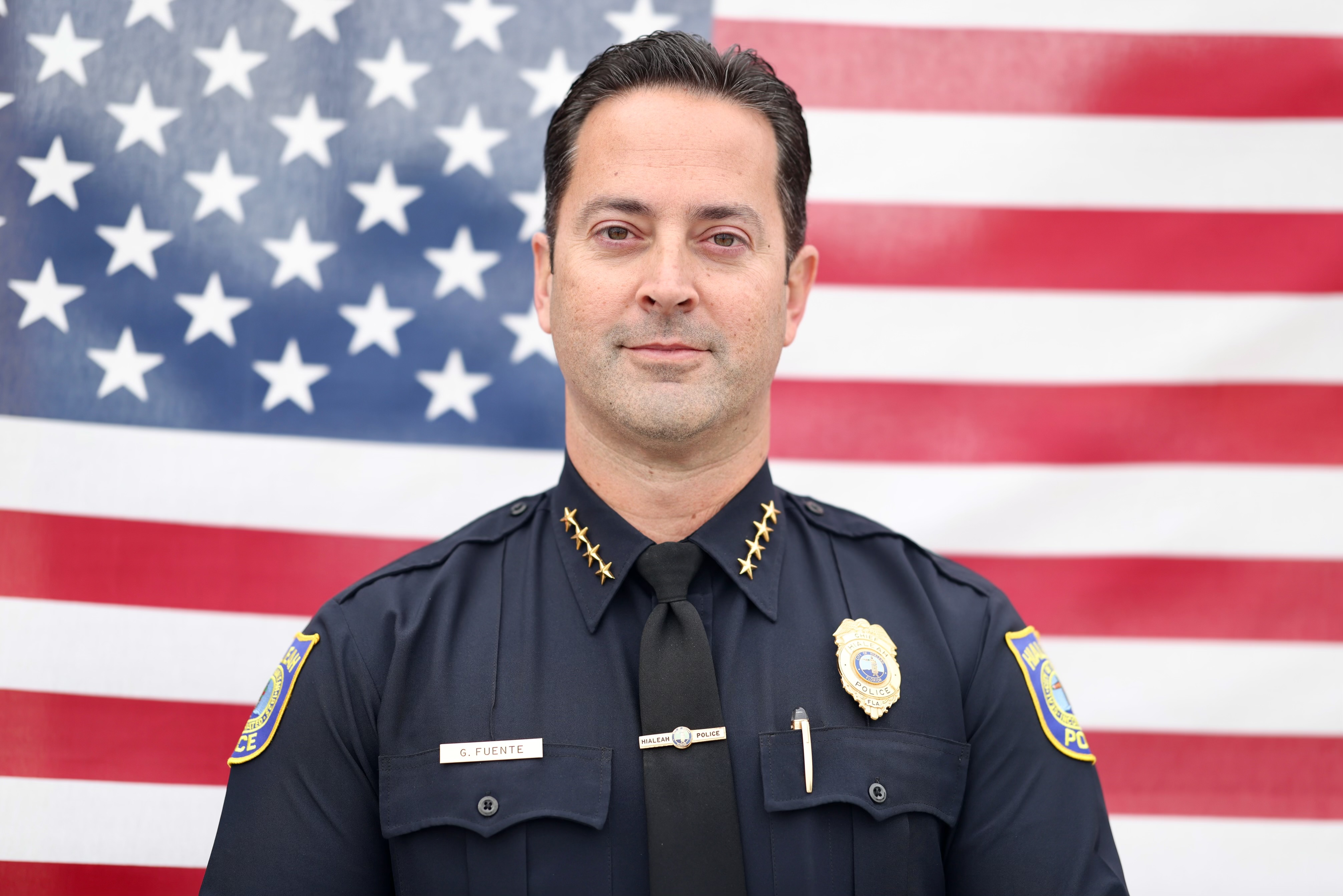 Officer in front of a US Flag.
