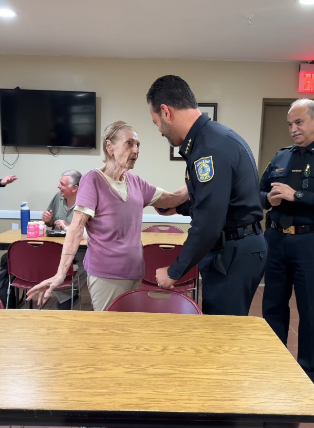Officers speaking with a lady at a table.