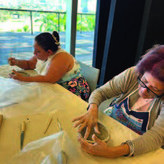 Two women crafting pottery.