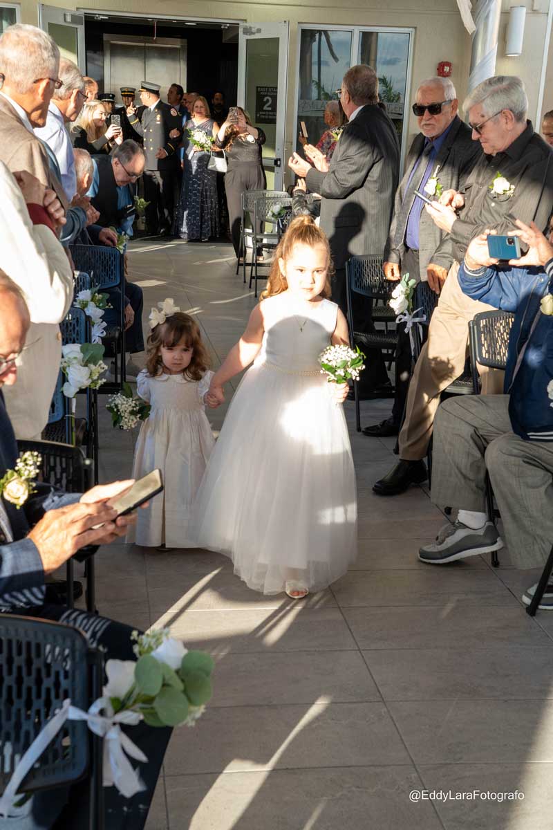 Two little girls walking down the aisle as flower girls.