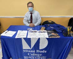 Man sitting at Miami Dade College table.