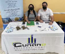Man and woman sitting at Cunano Builders Corp. Table. 