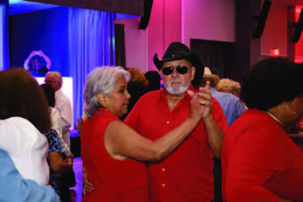 A couple wearing red dancing on the dance floor.