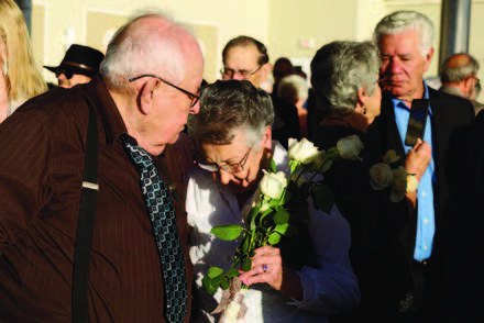 A man and a woman standing outside next to others.