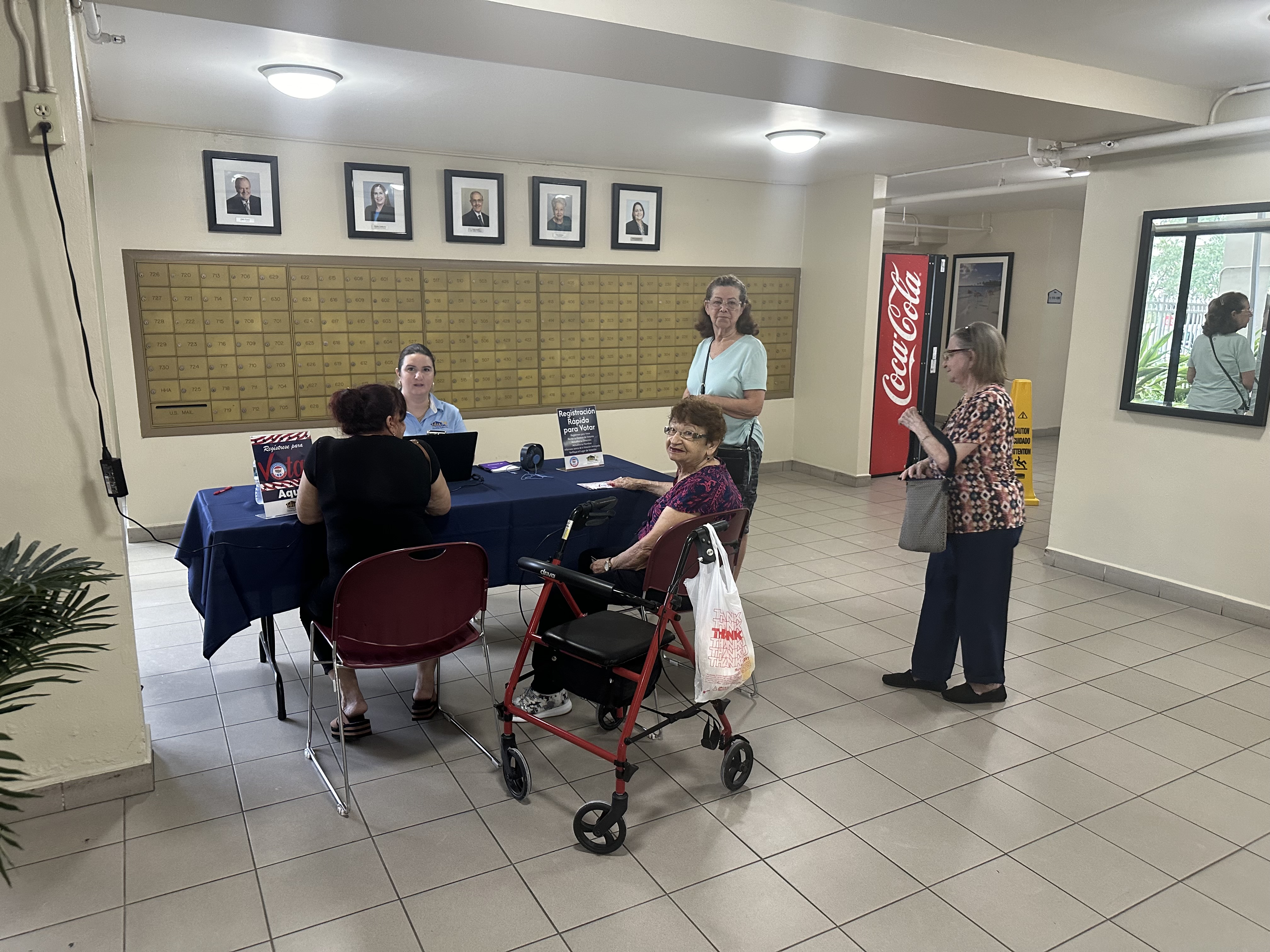 Several people at a table registering to vote.