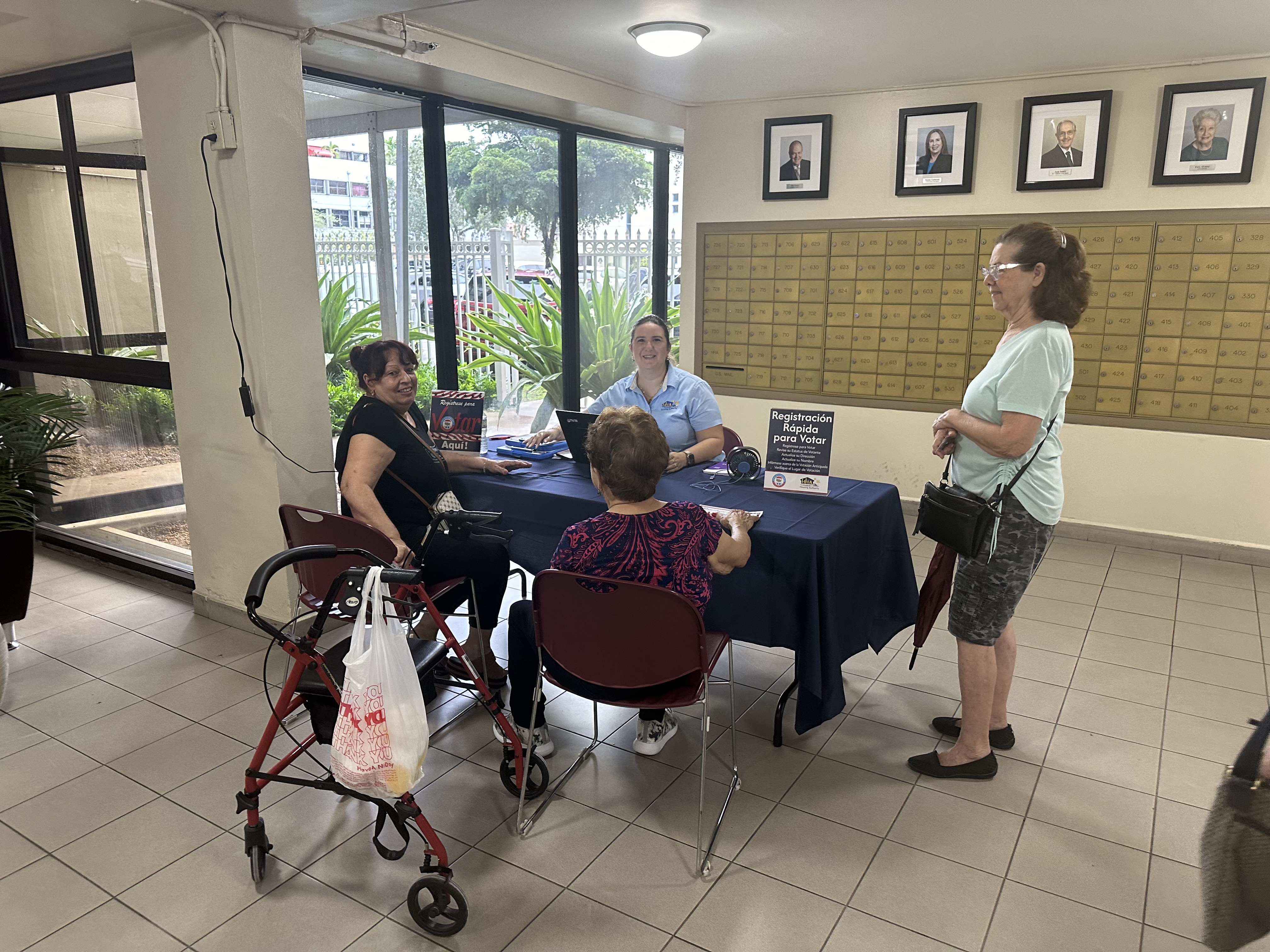 Several people at the spanish information table registering to vote.
