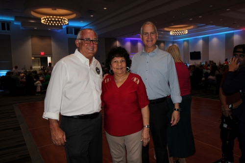 Two men and a woman standing together.