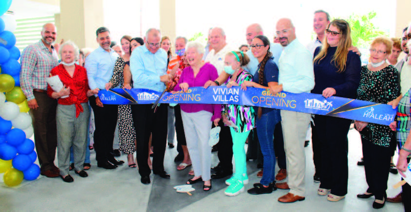 Individuals participating in a ribbon cutting.