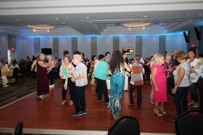 various residents standing on the dance floor visiting.