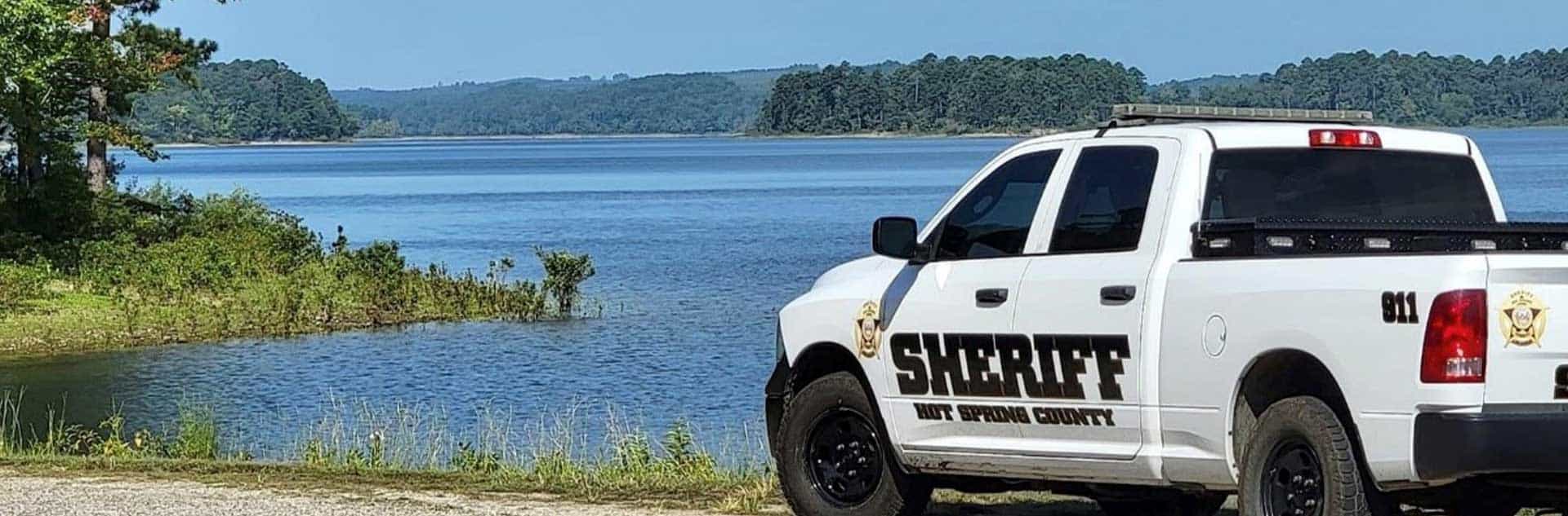 A Hot Spring County Sheriff patrol truck in front of a lake.