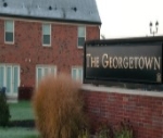 Partial view of a building behind a sign with The Georgetown on it.