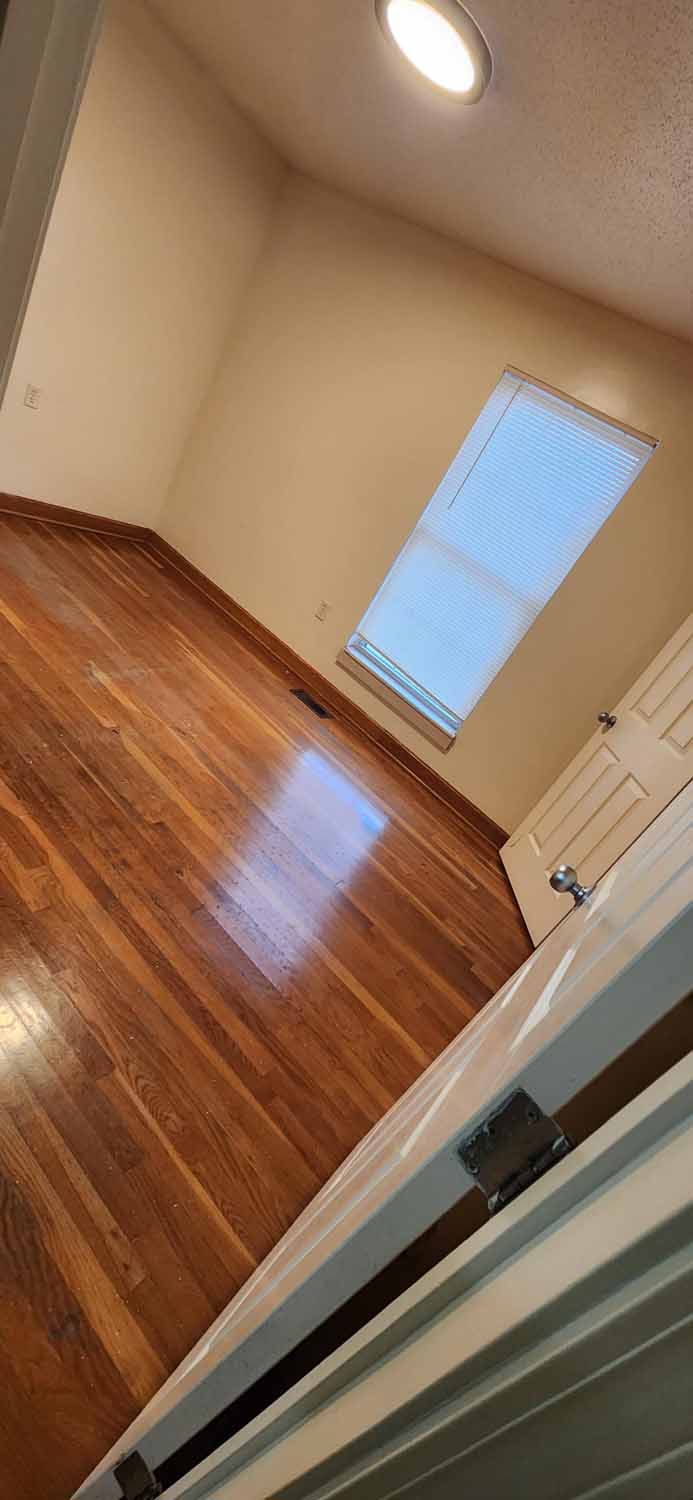 A bedroom with hard wood floors.