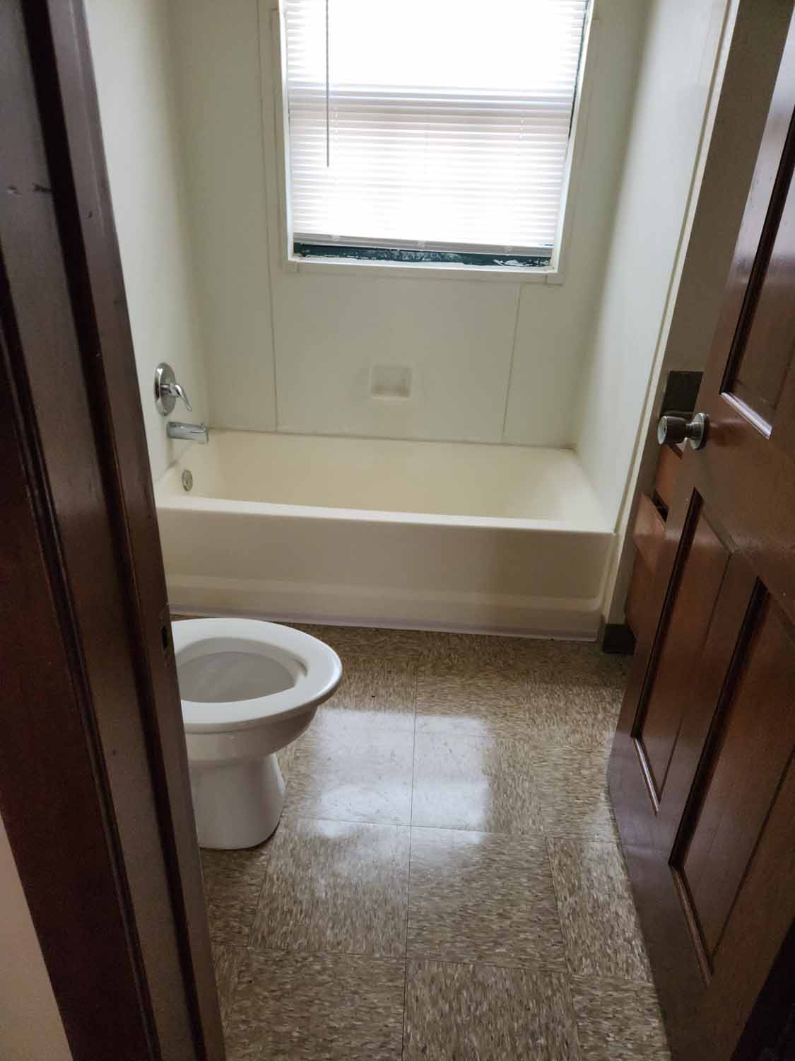 A bathroom with view of a toilet.
