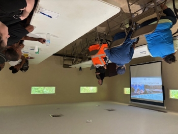 A group of people sitting in a room watching a presentation.