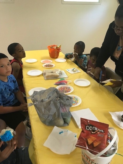 Kids at a table about to decorate cookies.