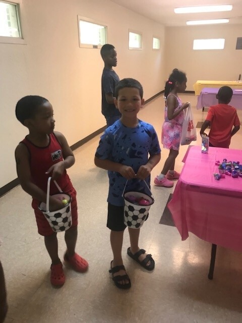 Kids at the Easter egg hunt with baskets of eggs.