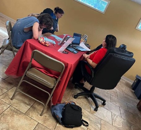 People seated at the TRIO table with a person talking to them.