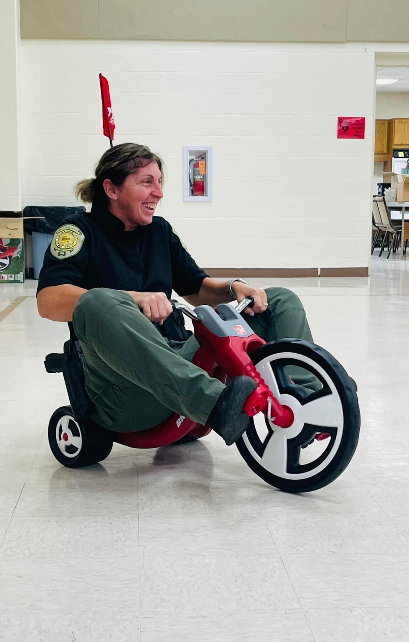 Chief Deputy Melte riding a trike at the Kindergarten roundup 