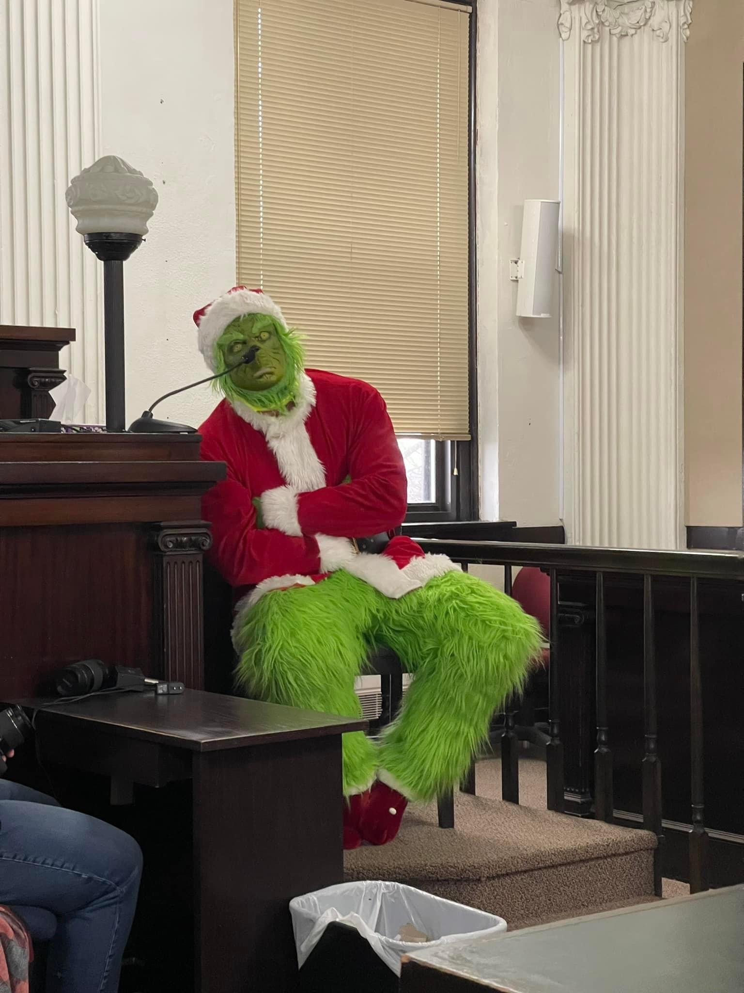 The Grinch sitting at the witness stand