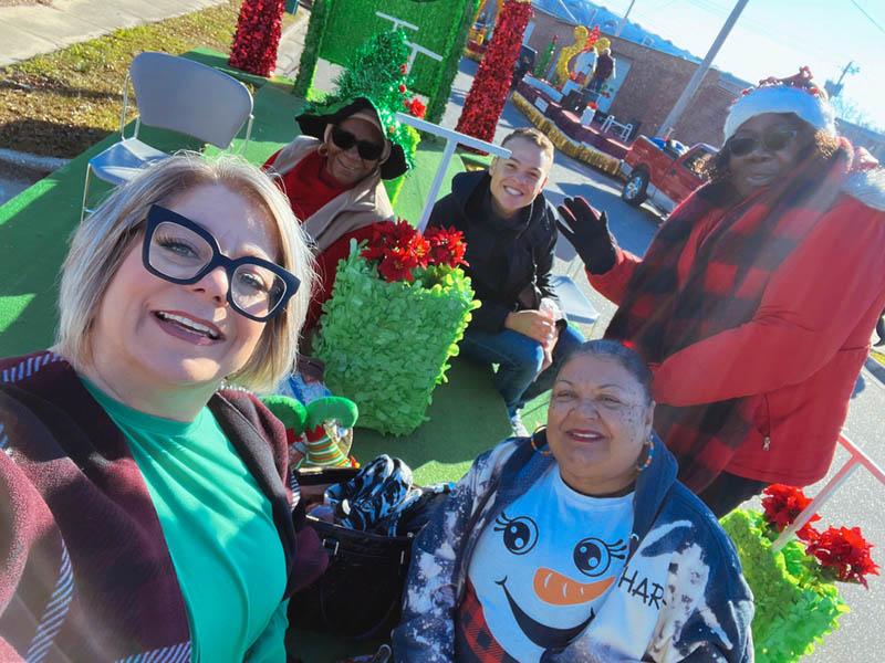 Individuals on a float in a Christmas parade.