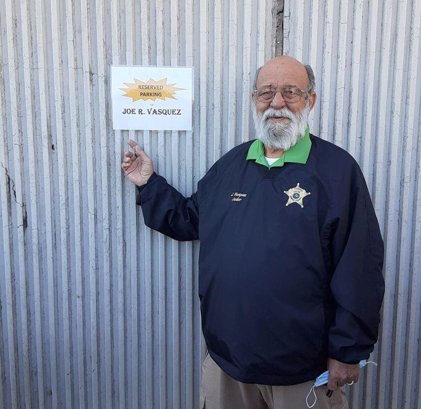 Joe Vasquez in front of his reserved parking spot placard.