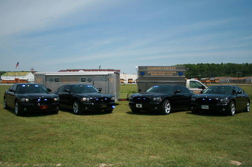 Four Marion County Sheriff's patrol cars in a field.