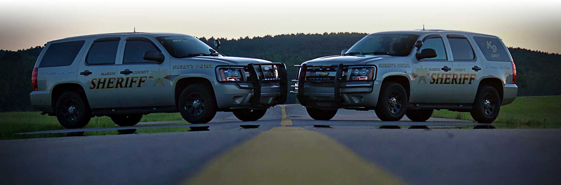 Two Marion County Sheriff SUVs facing each other on the road.