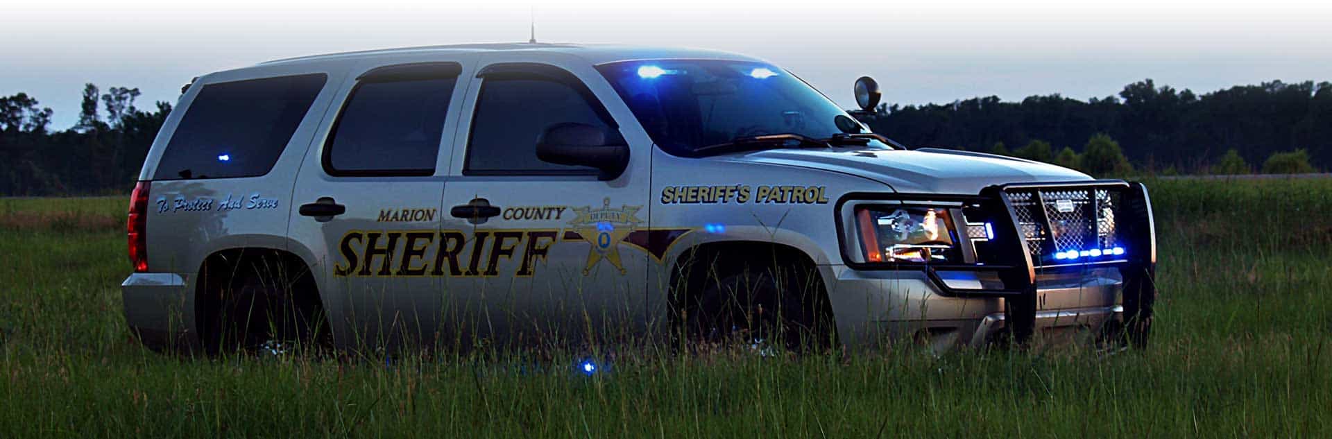 A Marion County Sheriff patrol vehicle in a grassy field.