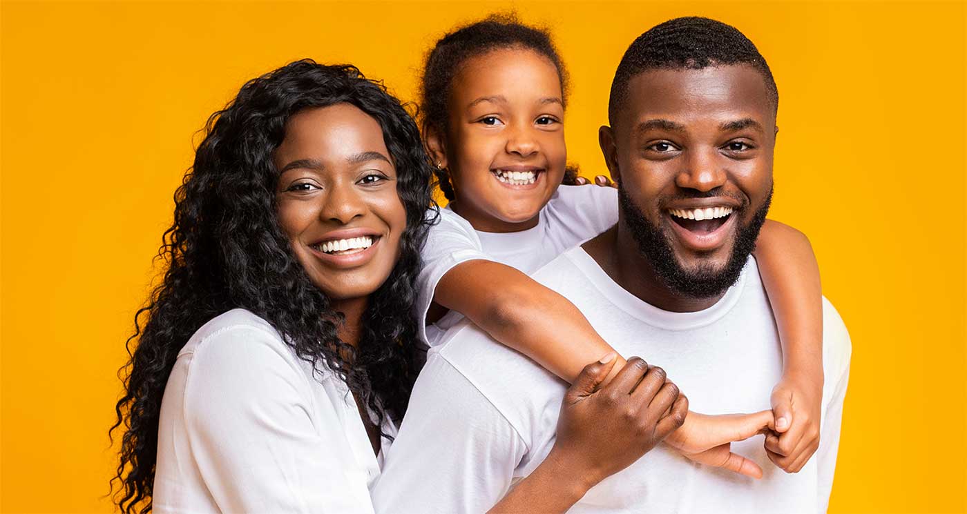 Family posing with child on dad's back